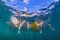 Underwater photo of surfers sitting on surf boards