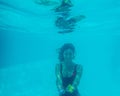 Underwater photograph of blonde girl with curls and red swimsuit