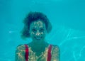 Underwater photograph of blonde girl with curls and red swimsuit