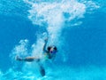 Underwater photography of little girl dives to the bottom of swimming pool Royalty Free Stock Photo
