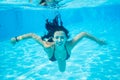 Underwater portrait of smiling female wearing in a black bathing suit in swimming pool, beautiful turquoise water Royalty Free Stock Photo