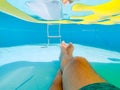 Pov of a man relaxing in the pool under a floating air mattress Royalty Free Stock Photo