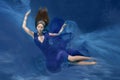 Underwater Queen. Girl mermaid. Underwater scene. A woman, a fashion model in the water in a beautiful dress swims like a fish Royalty Free Stock Photo