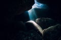 Underwater rocky cave in ocean with sun rays Royalty Free Stock Photo