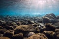 Underwater scene with stones and sun rays in blue sea Royalty Free Stock Photo