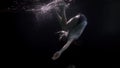 underwater shot of woman fallen in pool or sea, subaquatic slow motion shot, dressed young lady