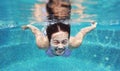 Underwater shot of young woman diving into the swimming pool Royalty Free Stock Photo