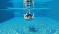 Underwater shot of young woman diving into the swimming pool Royalty Free Stock Photo