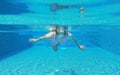Underwater shot of young woman diving into the swimming pool Royalty Free Stock Photo