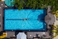 Underwater swimmer man diving in the luxury villa swimming pool. Aerial top shot. Careless summer vacation concept image Royalty Free Stock Photo