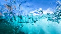 UNDERWATER: Turquoise water splashes over the camera submerged in the ocean. Royalty Free Stock Photo