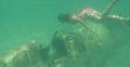 UNDERWATER: Unrecognizable female snorkeler looks at cockpit of sunken airplane. Royalty Free Stock Photo