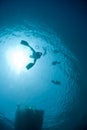 Underwater view of snorkellers sihouettes.