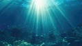 The underwater world in the ocean under the bright rays of the sun, breaking through the water surface to the bottom