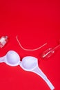 Underwear white bra, string of pearls and a glass on a red background, a place for text Royalty Free Stock Photo