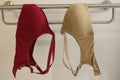 Underwire bras in multi colored hanging on the iron stainless hangers.