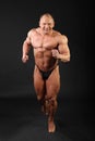 Undressed bodybuilder runs inside studio Royalty Free Stock Photo