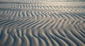 Undulating patterns form across a sandy surface, showcasing natural wind-created ripples. The sand Royalty Free Stock Photo