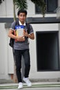 Unemotional Diverse Boy Student With Books Walking