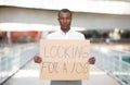 Unemployed black man holding placard with looking for a job text Royalty Free Stock Photo