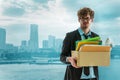 Unemployed Business man worker carrying packed box with upset expression for unemployment concept with modern city background Royalty Free Stock Photo