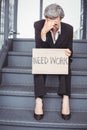 Unemployed businesswoman with need work placard