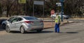 Unemployed caucasian parking attendant assisting motorists