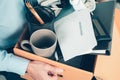 Unemployed hold cardboard box and resignation letter, dossier, alam clock, coffee cup, calculator and drawing tube in box. Quiting Royalty Free Stock Photo