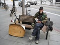 Unemployed man sitting on a bench and begging for money