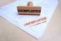 unemployed red rectangular grunge sign on documents, red text on white, Wooden vintage hand rubber stamp, concept of becoming Royalty Free Stock Photo