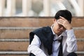 Unemployed stressed young Asian business man suffering from severe depression. Failure and layoff concept Royalty Free Stock Photo