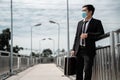 Unemployed stressed young Asian business man wear mask carry a job bag looking for work in suit covering face with Leaning against
