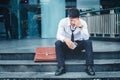 Unemployed Tired or stressed businessman sitting on the walkway