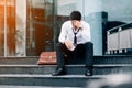 Unemployed tired or stressed businessman sitting on the walkway