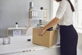 Unemployment Dismissed business woman upset with a cardboard box leaves the workplace from the office of the company.