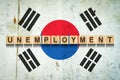 Unemployment. The inscription on wooden blocks on the background of the Korea flag. Unemployment growth. Business.