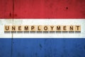 Unemployment. The inscription on wooden blocks on the background of the Netherlands flag. Unemployment growth. Business