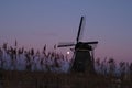 UNESCO World Heritage windmill stands as moon shines in Kinderdijk, near Rotterdam Netherlands Royalty Free Stock Photo