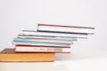 uneven stack of colorful Books lying on table, side view