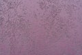 Uneven surface of purple wall with stucco worm finish