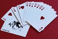 Game of imagination. Joker as obstacle to achievement of the goal. Fan of playing cards of suit of hearts and black joker on red