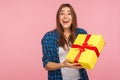 Unexpected present, holiday bonus! Portrait of surprised joyful pretty girl in checkered shirt holding wrapped box