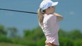 Unexperienced female golf player swinging to make shot and missing, slow-motion