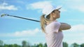 Unexperienced young woman making hits on golf course, practicing in golf, hobby