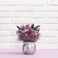 Unfading bouquet of natural plants, flowers, ears of wheat in small round vase.