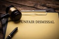 Unfair dismissal text on Document and gavel isolated on wooden office desk