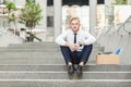 Unfair ginger worker sit on stair and seriosly looking at camera.