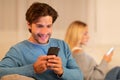 Unfaithful Boyfriend Chatting On Phone Sitting With Girlfriend At Home