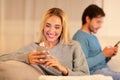 Unfaithful Girlfriend Chatting On Phone Sitting Next To Boyfriend Indoor