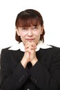 Unfashionable Asian businesswoman folding her hands in prayer Royalty Free Stock Photo